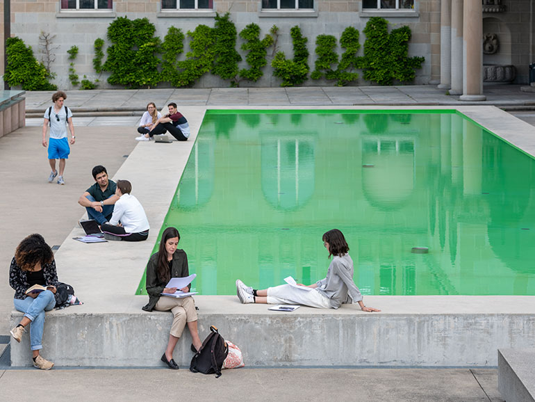 Studierende am Brunnen vor dem Hauptgebäude